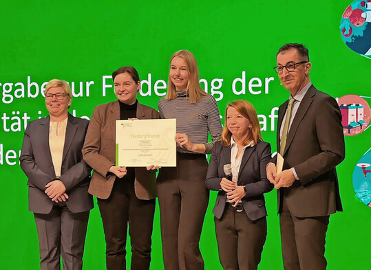 Bundeslandwirtschaftsminister Cem zdemir (r.) berreicht auf der Grnen Woche den Zuwendungsbescheid fr das Projekt SimpleAgriData an Verbundkoordinatorin Prof. Dr. Christine Preisach (2. v. r.) aus der Fakultt fr Informatik und Wirtschaftsinformatik der Hochschule Karlsruhe.