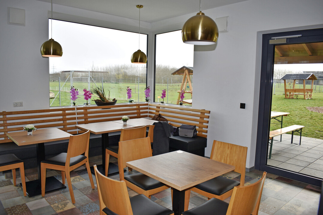 Das integrierte Hofcaf� mit Blick ins Gr�ne l�dt zum Verweilen ein. Die G�ste haben direkten Blick auf die umliegenden Fl�chen und Tierbereiche.