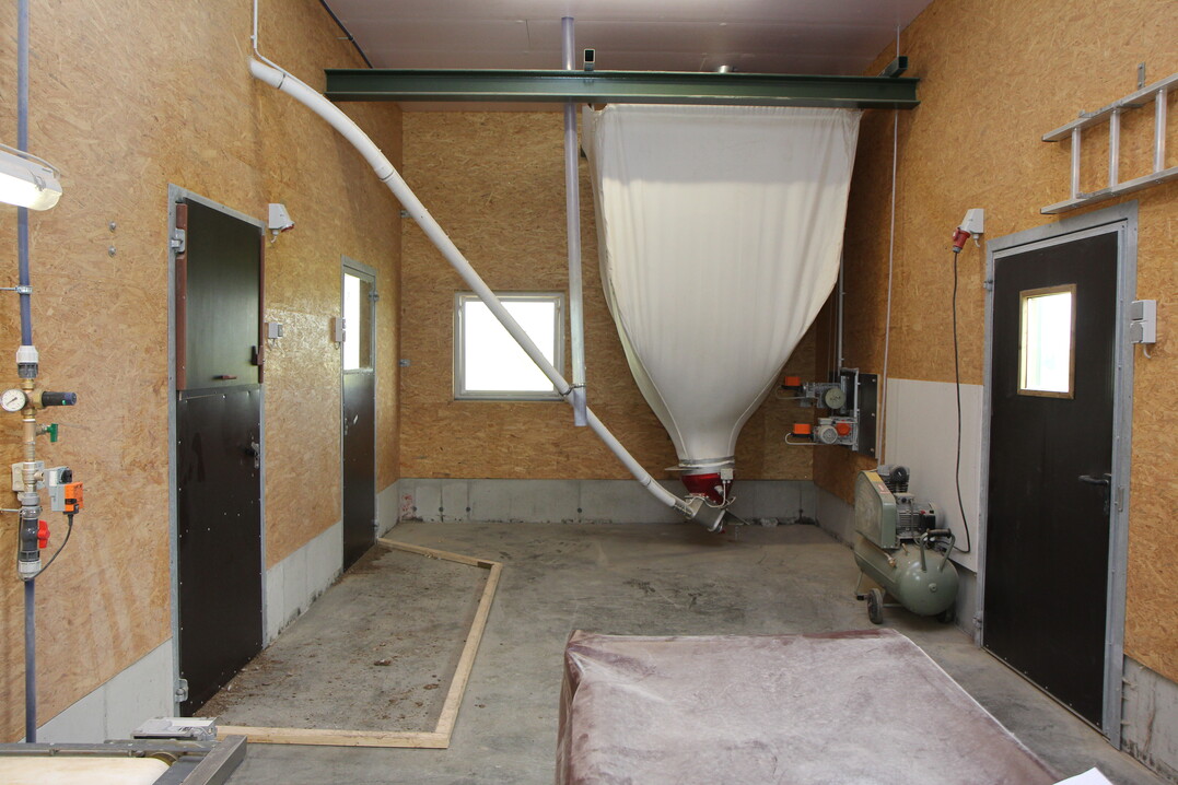 Der Vorraum mit Besucherfenster (eine Auflage der AFP-Frderung), Tagesvorratssilo und mit Holzlatten und mit Holzlatten abgegrenztem Weibereich.