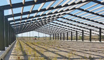 Seit Jahren ist der Stall der
zweiten Anlage im Rohbau
fertig. Er soll genauso aussehen, wie der in der Nähe
befindliche erste Stall mit
fast 40.000 Legehennen. Zum
Schutz der Baustelle konnte
gerade noch ein Zaun errichtet
werden, als ein zweiter Baustopp durch eine Verfügung
des BUND vor dem Verwaltungsgericht in Potsdam
durchgesetzt wurde.