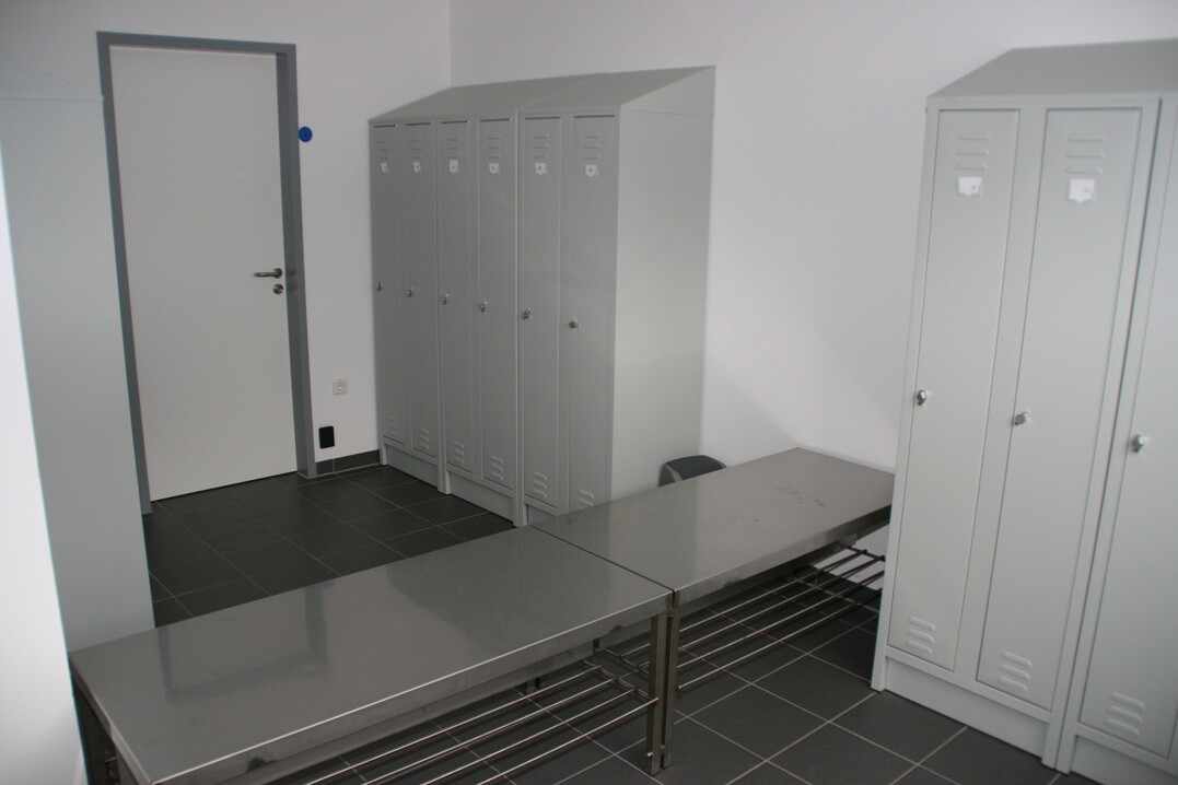 Die Bank in der Mitte des Umkleideraums dient als Hygienebarriere. Alle, die
in den Stall mchten, mssen durch diesen
Raum. Nach dem Umziehen vor der Bank
geht es ber die Bank, um die Stallschuhe
anzuziehen und die Hnde zu waschen.  
